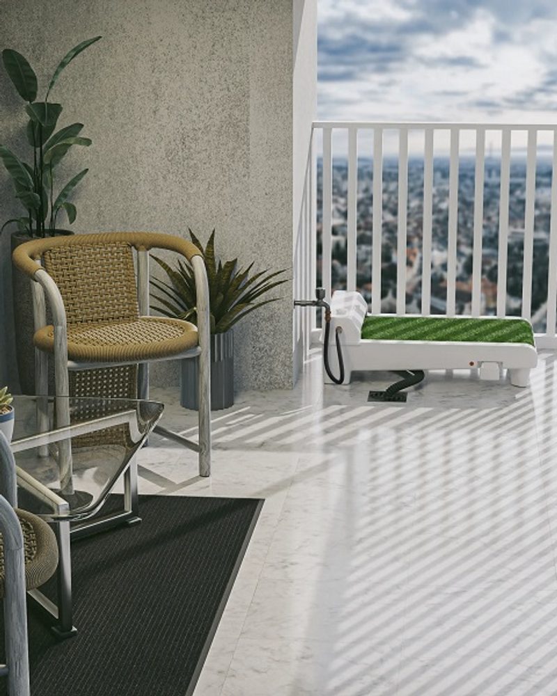 Fydoo self-cleaning dog toilet with synthetic grass installed on a modern apartment balcony with outdoor furniture.