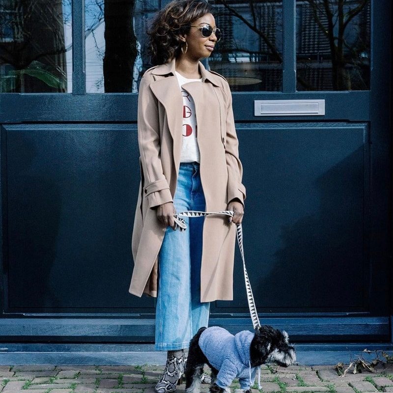 Stylish woman walking her dog wearing a blue hoodie and geometric leash from a Black-owned pet brand.