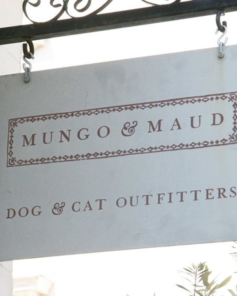 Mungo & Maud Dog & Cat Outfitters hanging metal storefront sign.