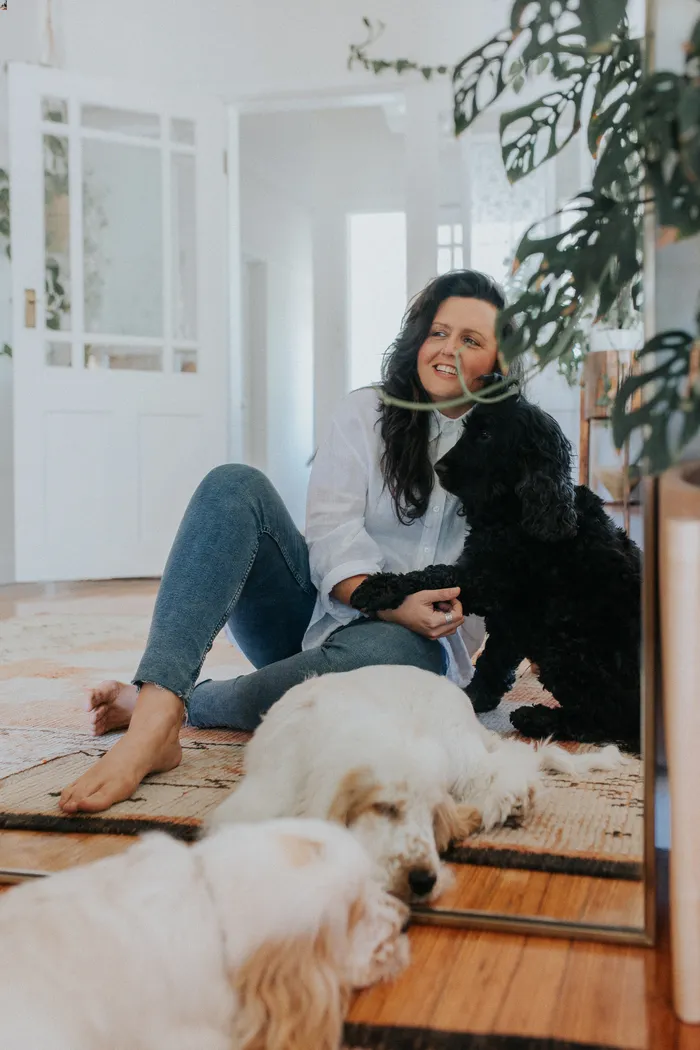Lifestyle image of dog mum at home with two cocker spaniels