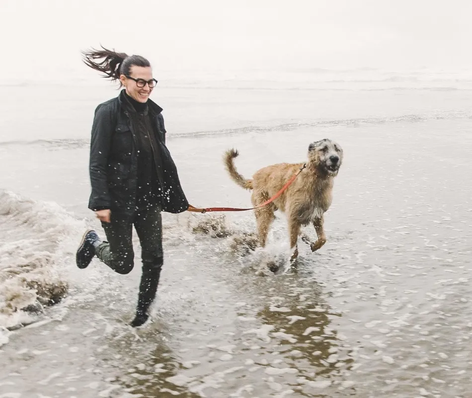 dog and woman running at the beach with silicone dog lead and collar